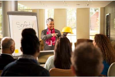 Woman holding a hard hat instructing a safety class