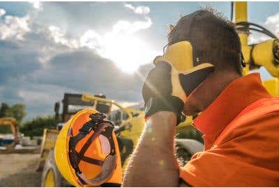 Construction worker wearing safety earmuffs to limit noise exposure