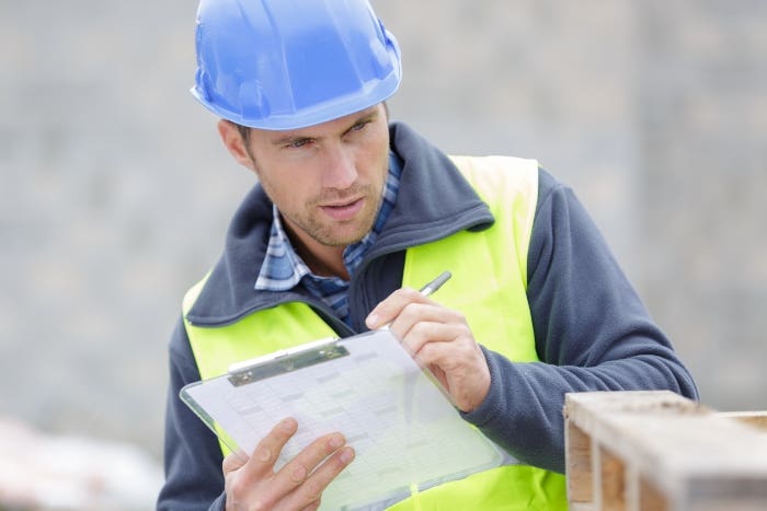 Worker holding clipboard and looking to the side